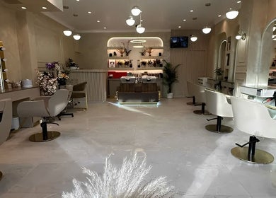 Spacious interior of Roza Hair Saloon, London, England, GB, featuring modern styling stations with ornate mirrors.