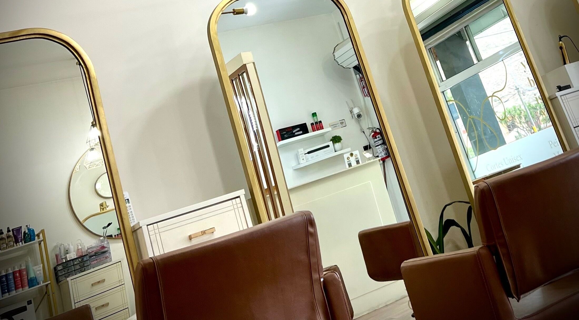 Interiores sofisticados de Valcassi en Ensenada, Baja California, MX con espejos dorados y sillas de cuero.