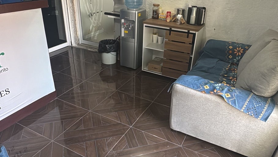 Área de recepción en Centro De Masajes Terapéuticos, Manzanillo, Colima, MX, con sofá y dispensador de agua.