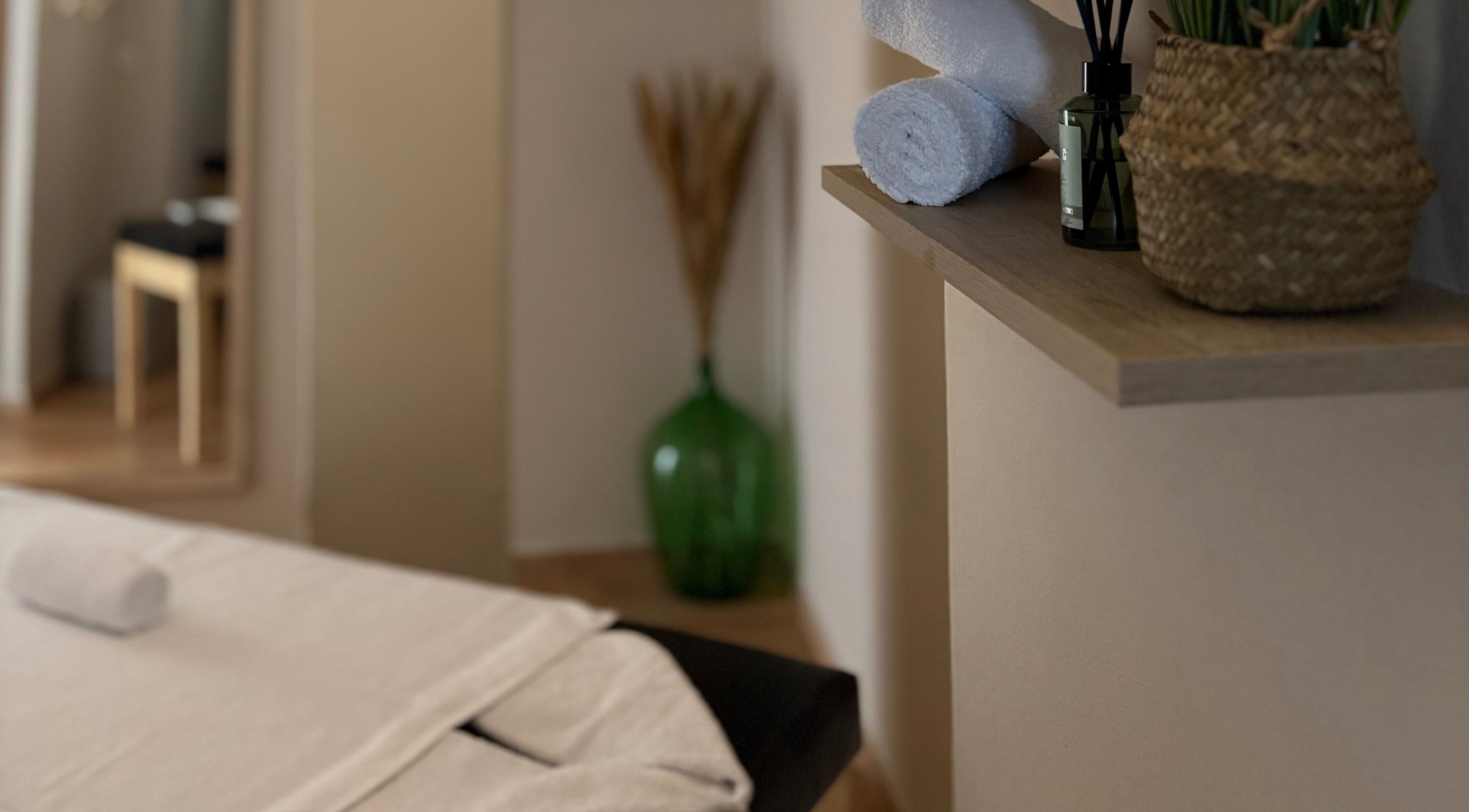 Χαλαρωτικός χώρος στο Serenity Massage Experience, Λάρισα, GR, με πετσέτες και αρωματικά.