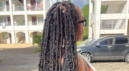 Dreadlocks styled at Tressed By Jai in Roseau, Saint George Parish, DM, with apartments in the background.