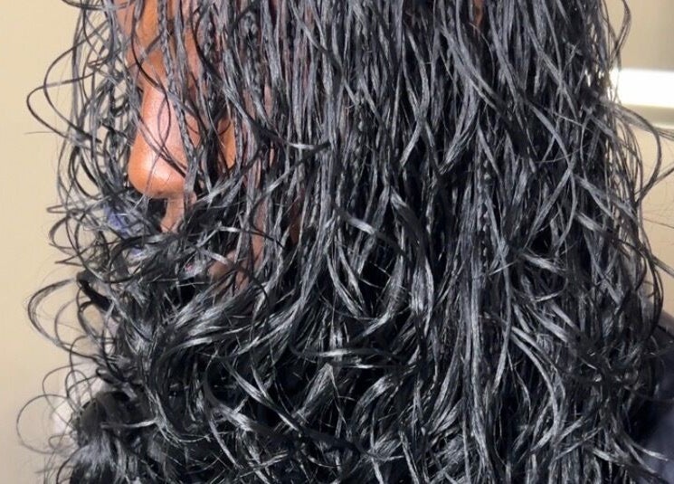 Close-up of shiny, wet curls styled at Olutey in Toronto, Ontario, CA, showcasing sleek and healthy hair.