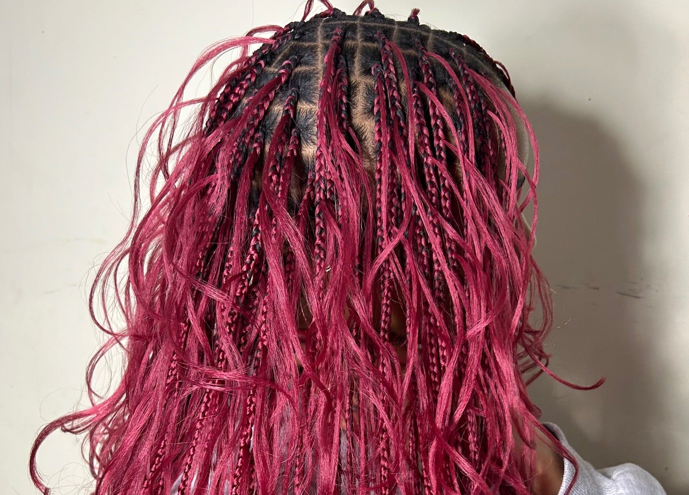 Intricate pink braided hairstyle at Olutey in Toronto, Ontario, CA showcasing vibrant hair design.