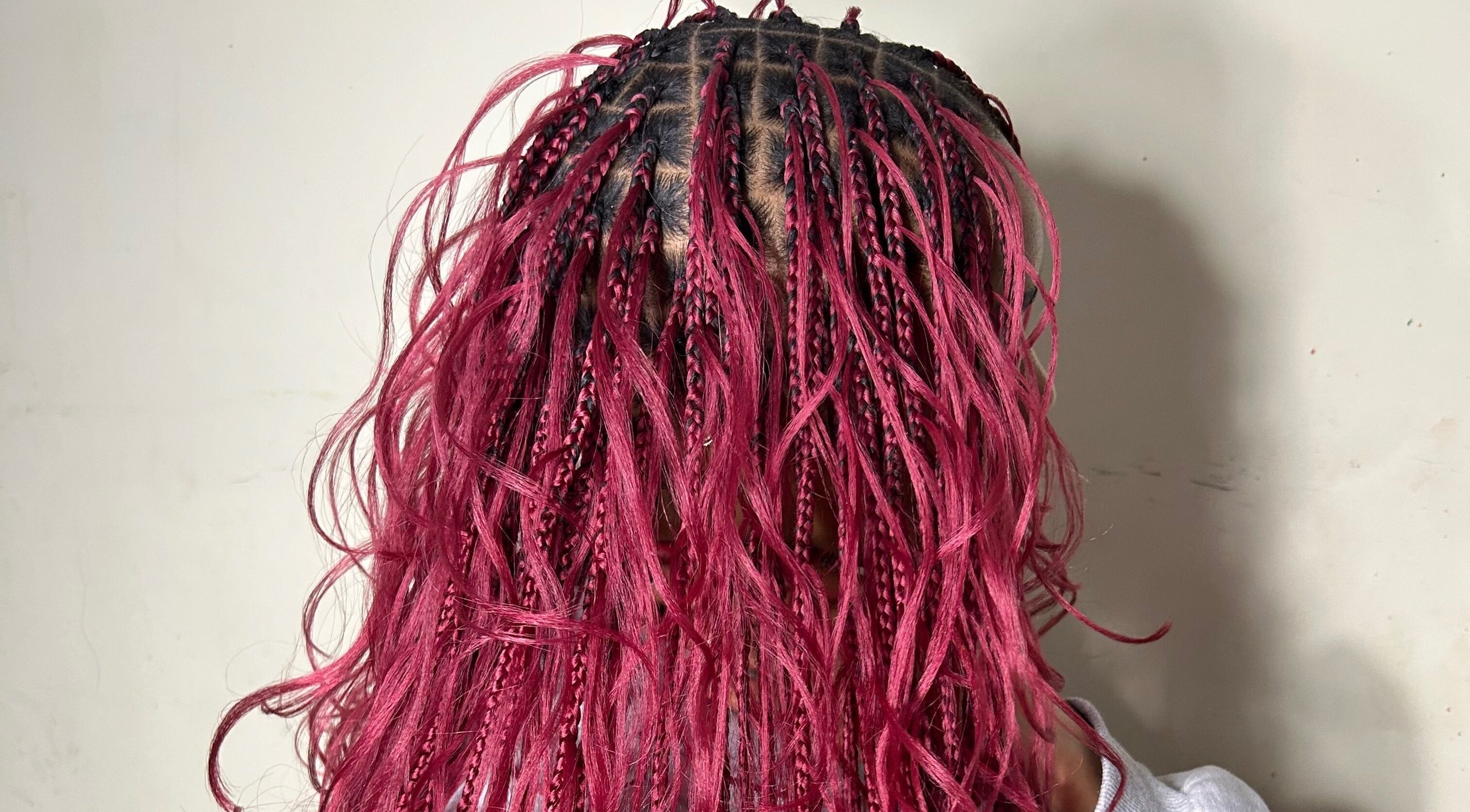 Intricate pink braided hairstyle at Olutey in Toronto, Ontario, CA showcasing vibrant hair design.
