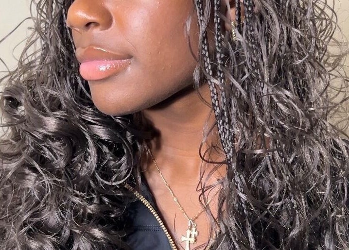 Close-up of glossy curls at Olutey in Toronto, Ontario, CA showcasing intricate braided and curled hairstyle.