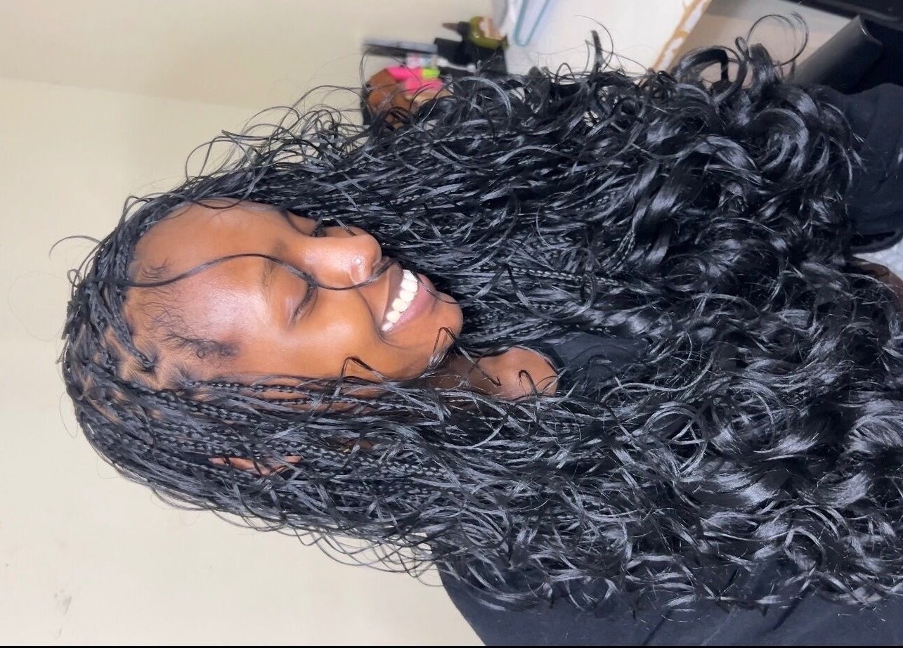 Smiling woman with curly hair at Olutey, Toronto, Ontario, CA, showcasing beauty services.