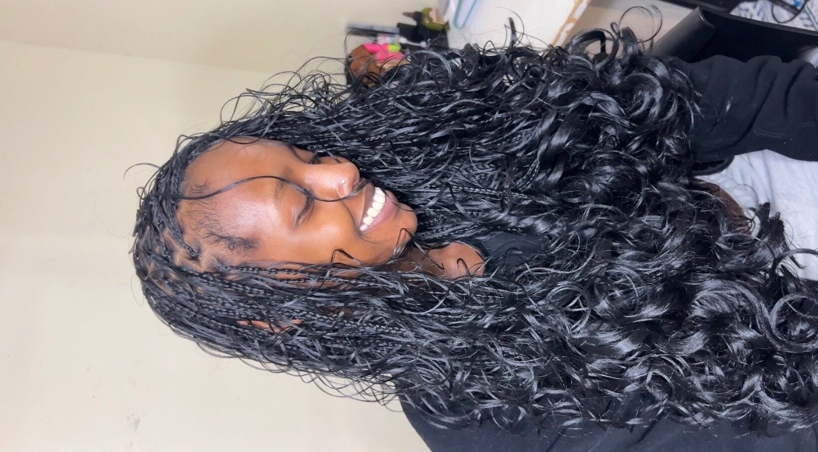 Smiling client with long curly hair styled at Olutey, Toronto, Ontario, CA.