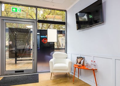 Cozy waiting area at Lash Zone London, featuring a white chair and orange table, London, England, GB.