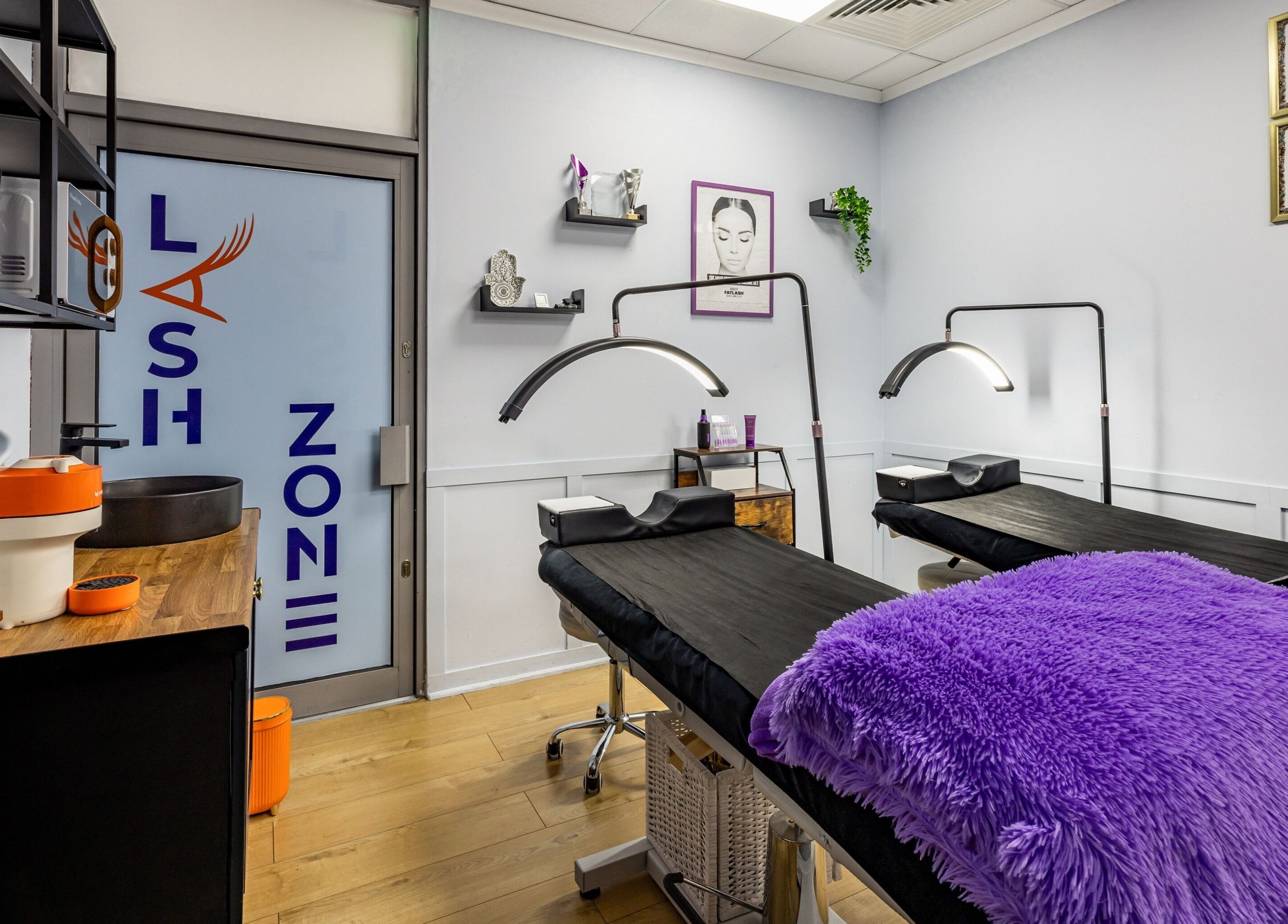 Modern treatment room at Lash Zone London, featuring plush purple pillows and soft lighting in London, England, GB.