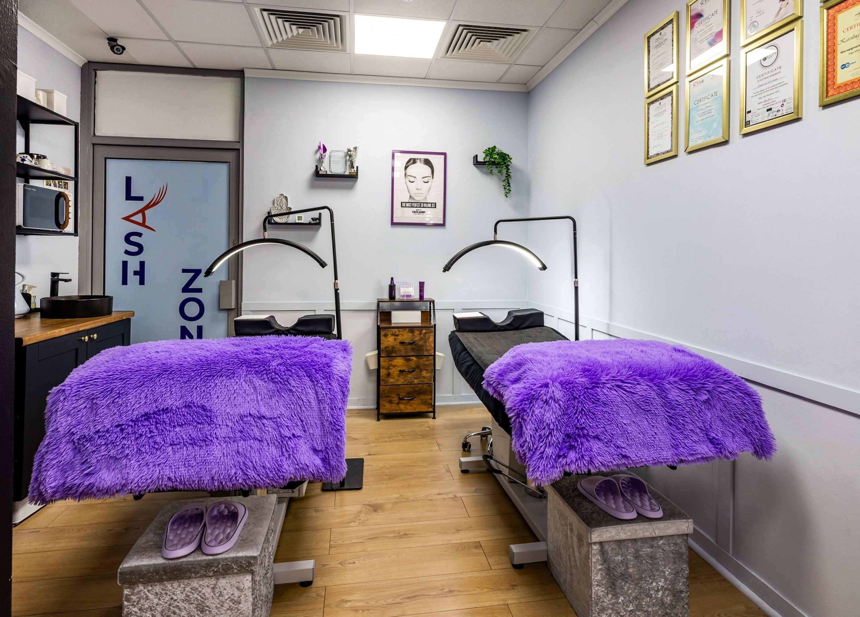 Cozy treatment room at Lash Zone London in London, England, GB with purple blankets and certificates displayed.