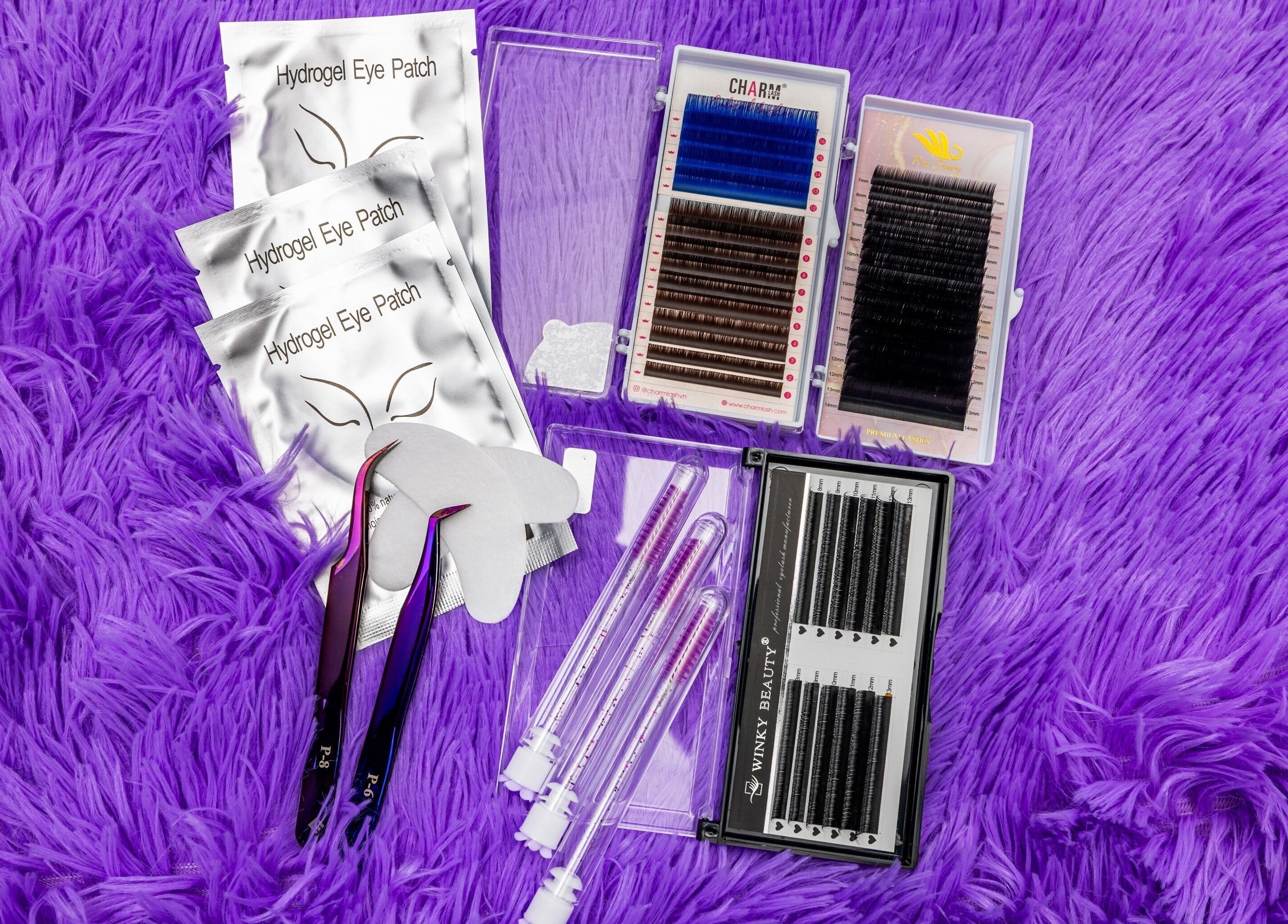 Eyelash extension tools and patches at Lash Zone London, London, England, GB, on a purple fuzzy background.