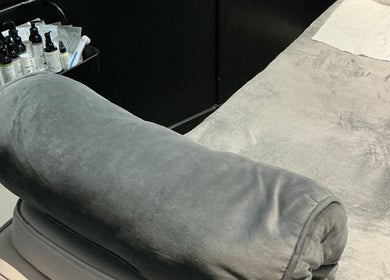 Comfortable treatment bed at GB Skin and Laser Salon, Forfar, Scotland, GB with plush grey cushioning.