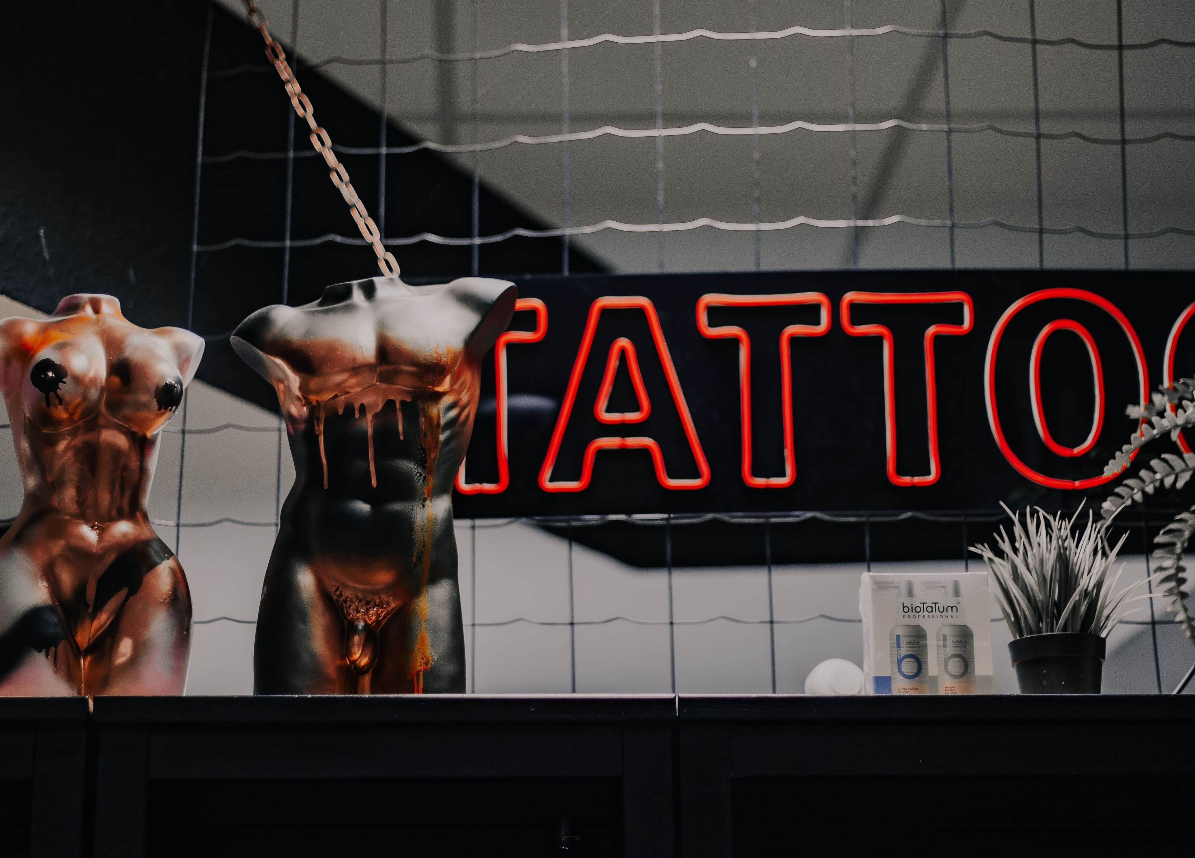 Innenansicht von VeAn TATTOO Berlin RED, Berlin, DE mit Dekoration und Neon-Tattoo-Schild.