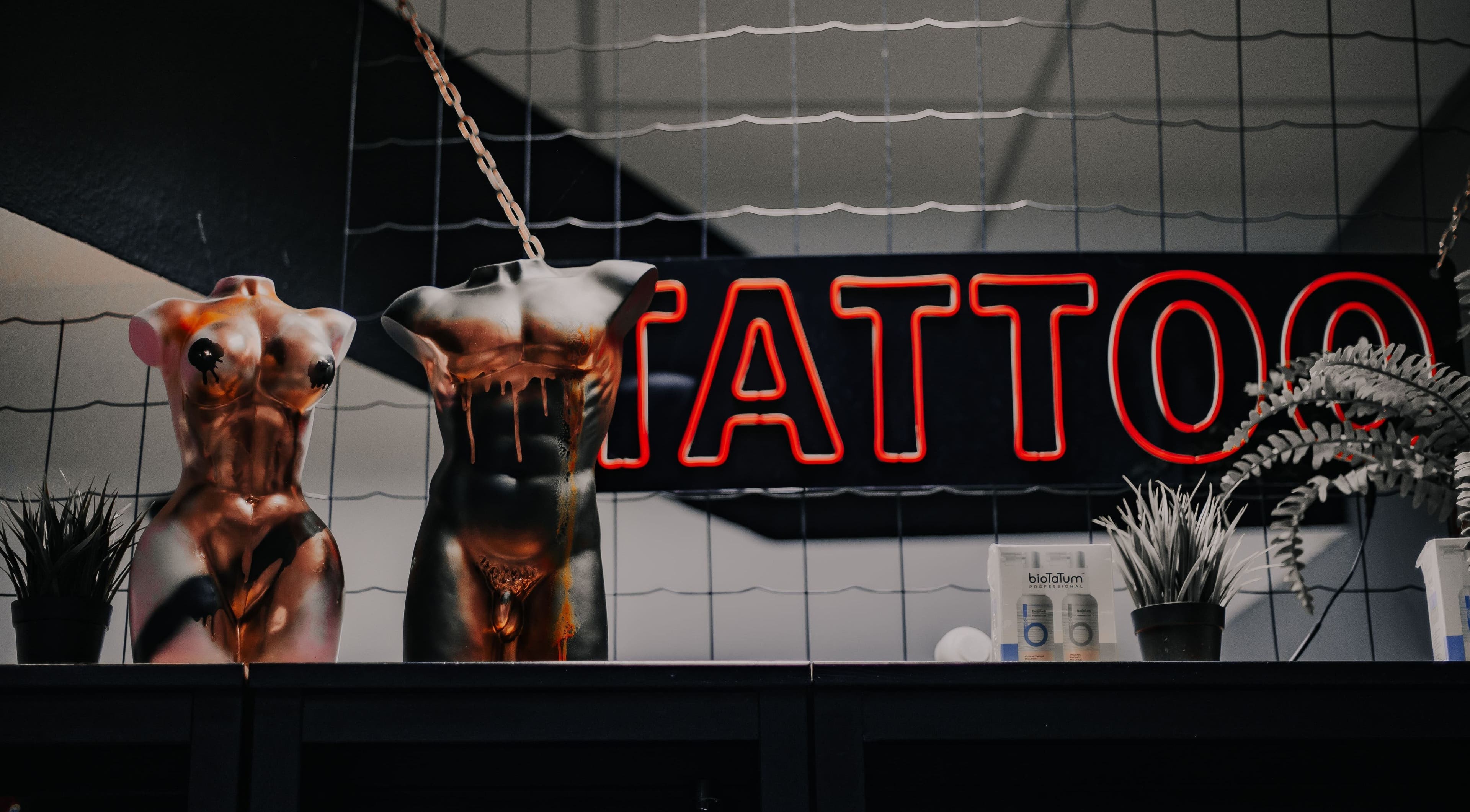 Innenansicht von VeAn TATTOO Berlin RED, Berlin, DE mit Dekoration und Neon-Tattoo-Schild.