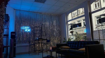 Stilvolle Lounge im Vean TATTOO Gotha, Thüringen, DE mit 'Sorry Mom' Neonlicht und gemütlichem Ambiente.