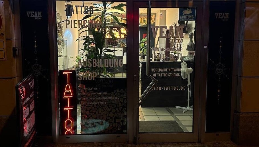 Frontansicht von VeAn Tattoo Dresden bei Nacht, mit beleuchteten Schildern in Dresden, Sachsen, DE.