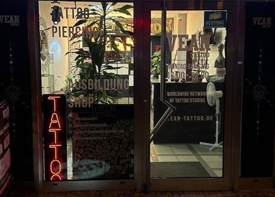 Frontansicht von VeAn Tattoo Dresden bei Nacht, mit beleuchteten Schildern in Dresden, Sachsen, DE.