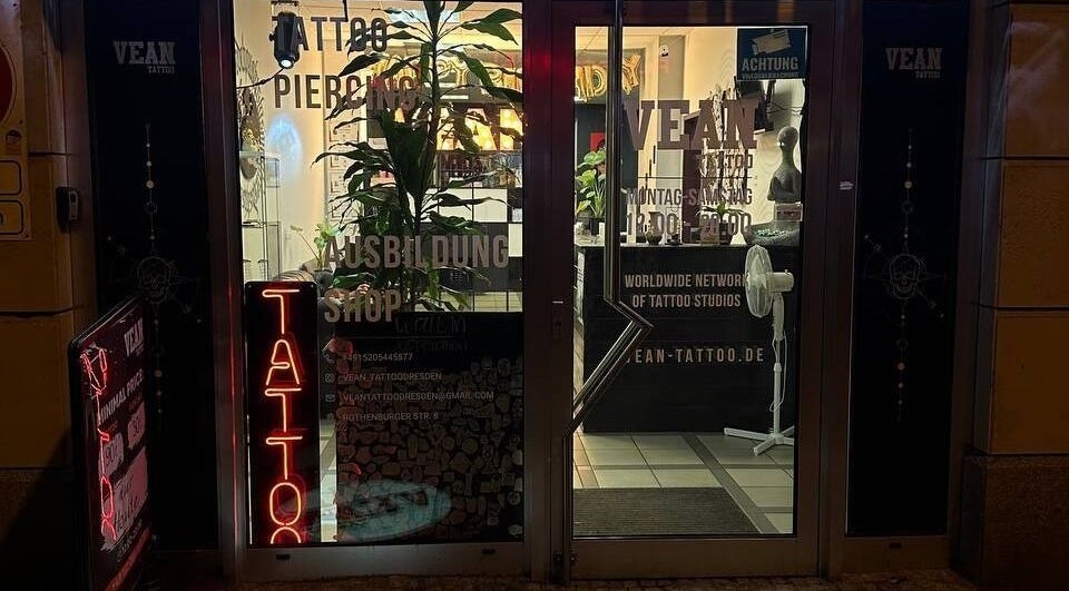 Frontansicht von VeAn Tattoo Dresden bei Nacht, mit beleuchteten Schildern in Dresden, Sachsen, DE.