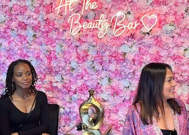 Women at LC Beauty Bar's floral wall in Apopka, Florida, US.