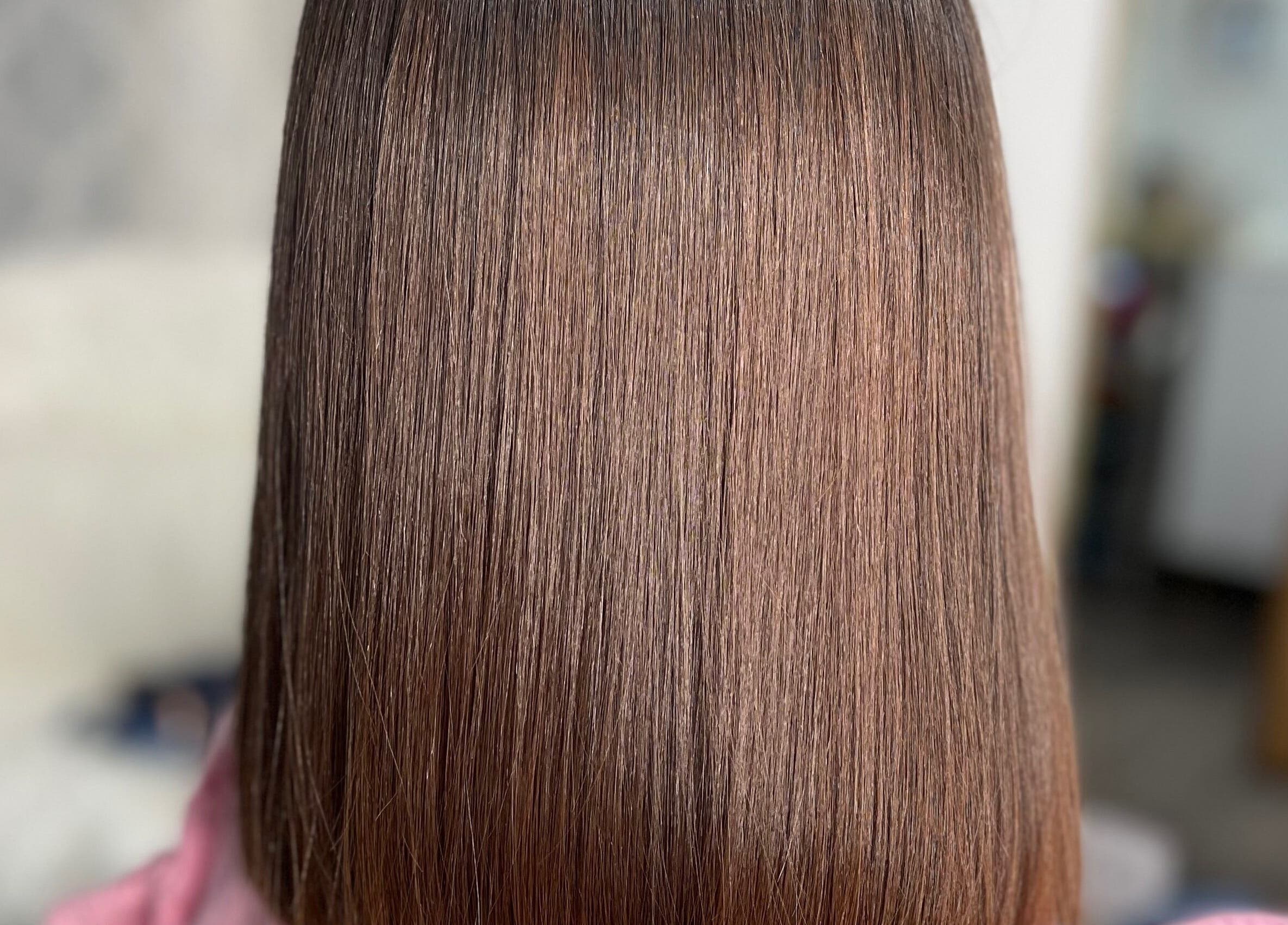 Sleek brunette hairstyle at Lucas Hair Loft in Tampa, Florida, US showcasing shiny, straightened hair.