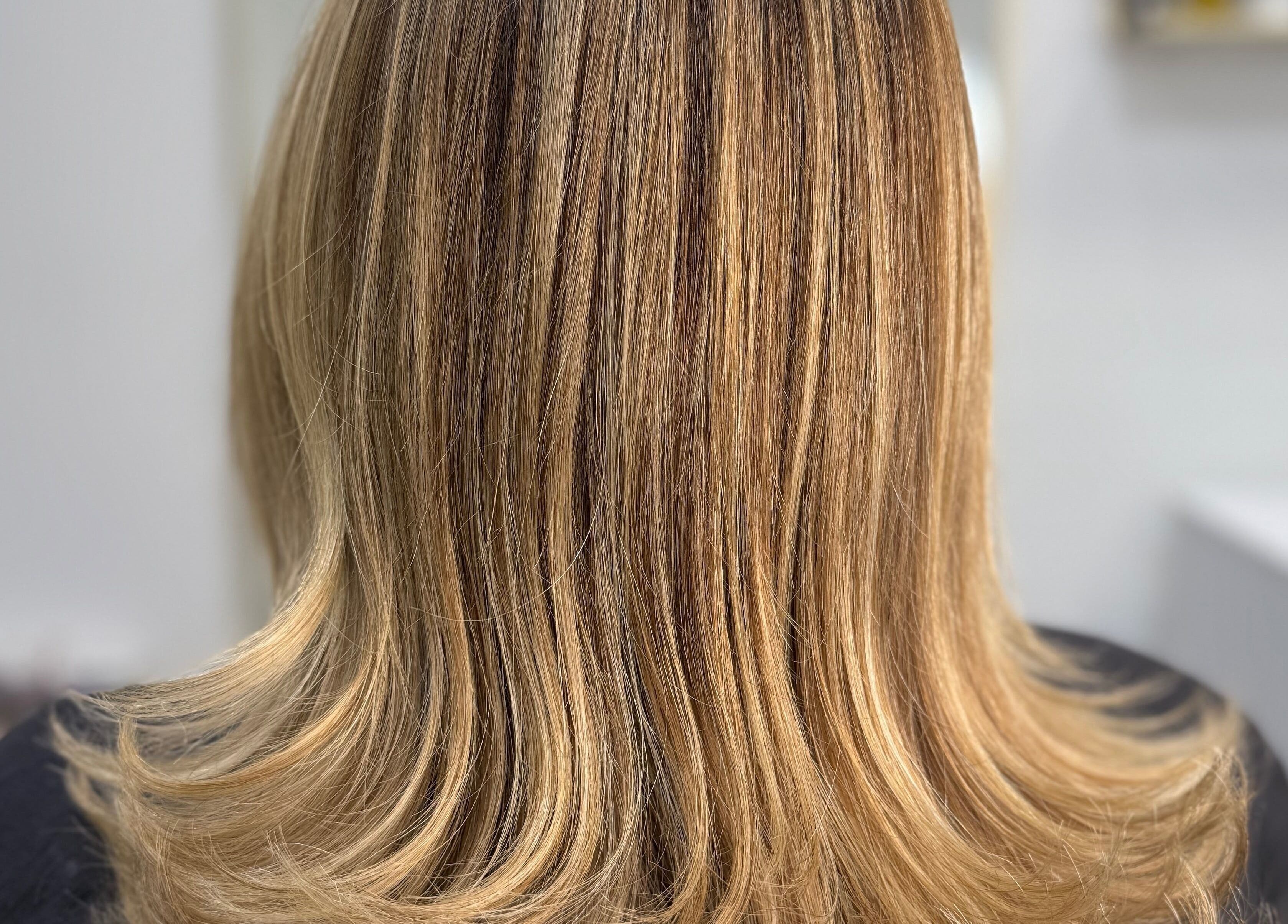 Stylish blonde haircut at Lucas Hair Loft, Tampa, Florida, US showcasing sleek, straight hair with subtle highlights.