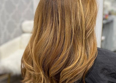 Stylish golden blonde hair at Lucas Hair Loft in Tampa, Florida, US, showcasing soft waves.