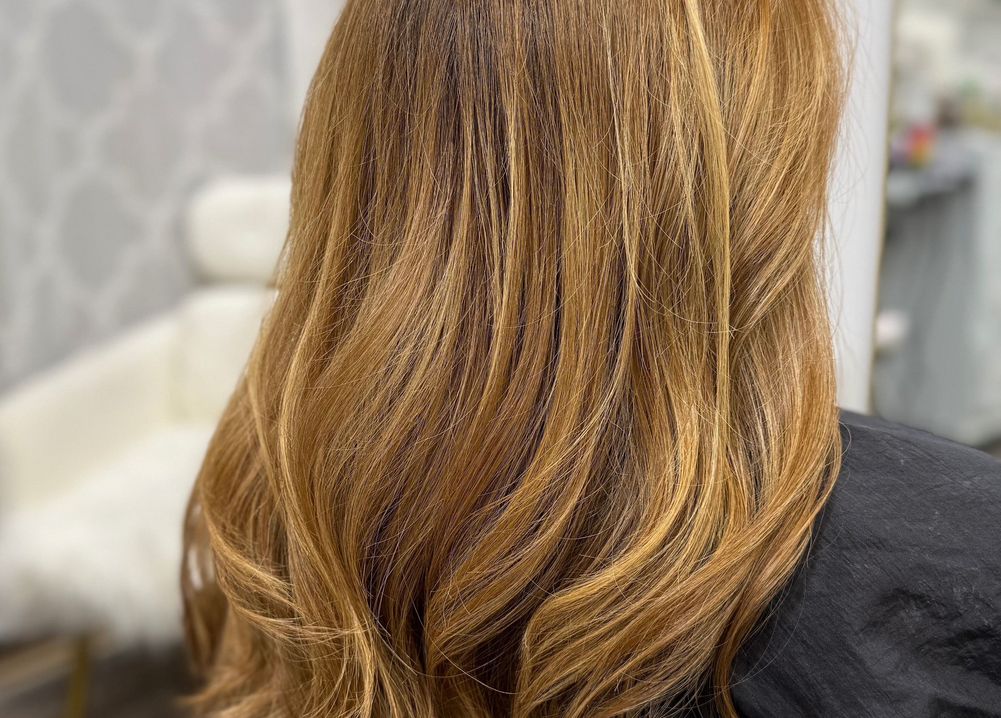 Stylish golden blonde hair at Lucas Hair Loft in Tampa, Florida, US, showcasing soft waves.