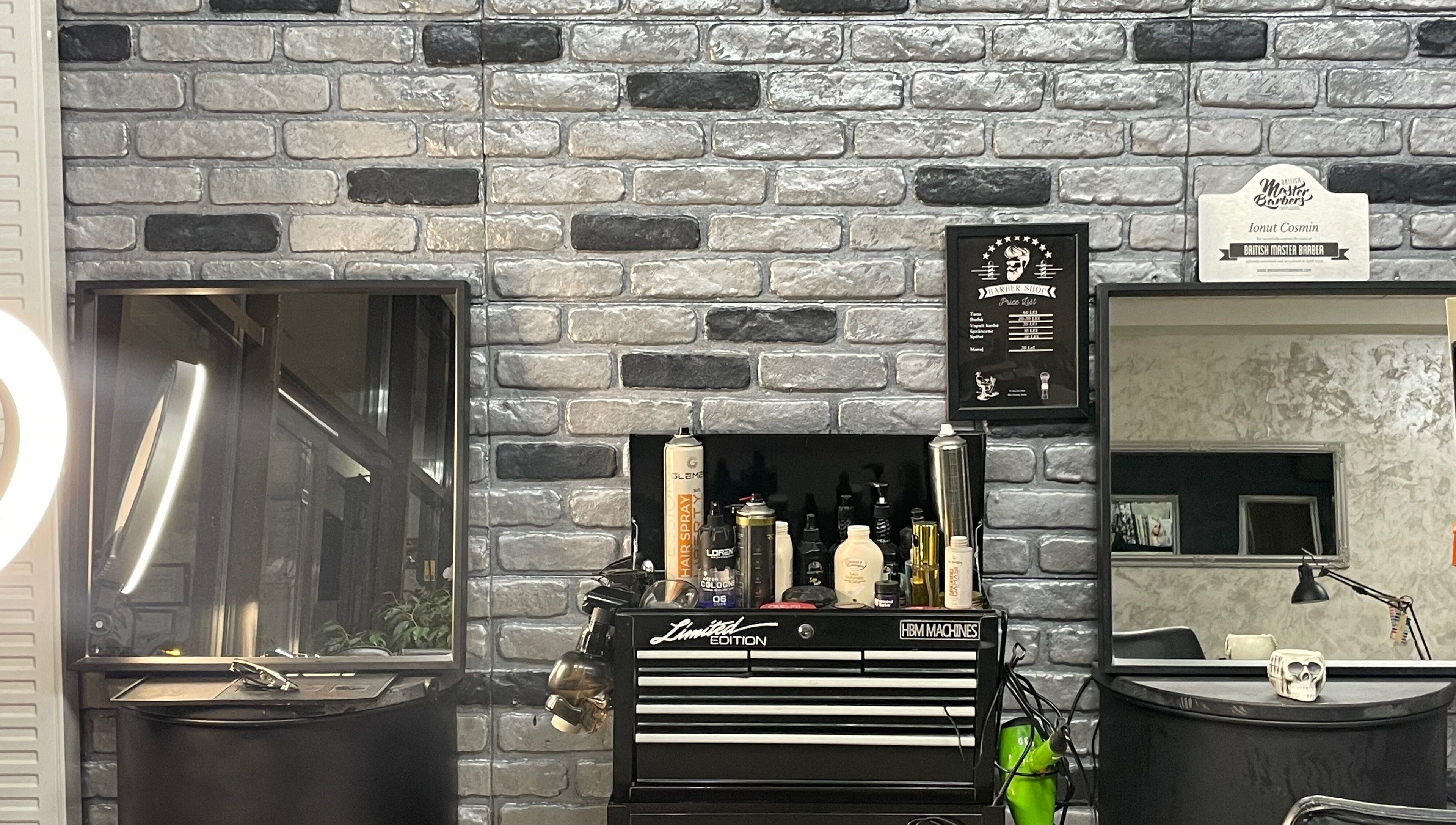 Interior modern Barber din București, București, RO, cu produse de îngrijire pe perete cărămiziu.