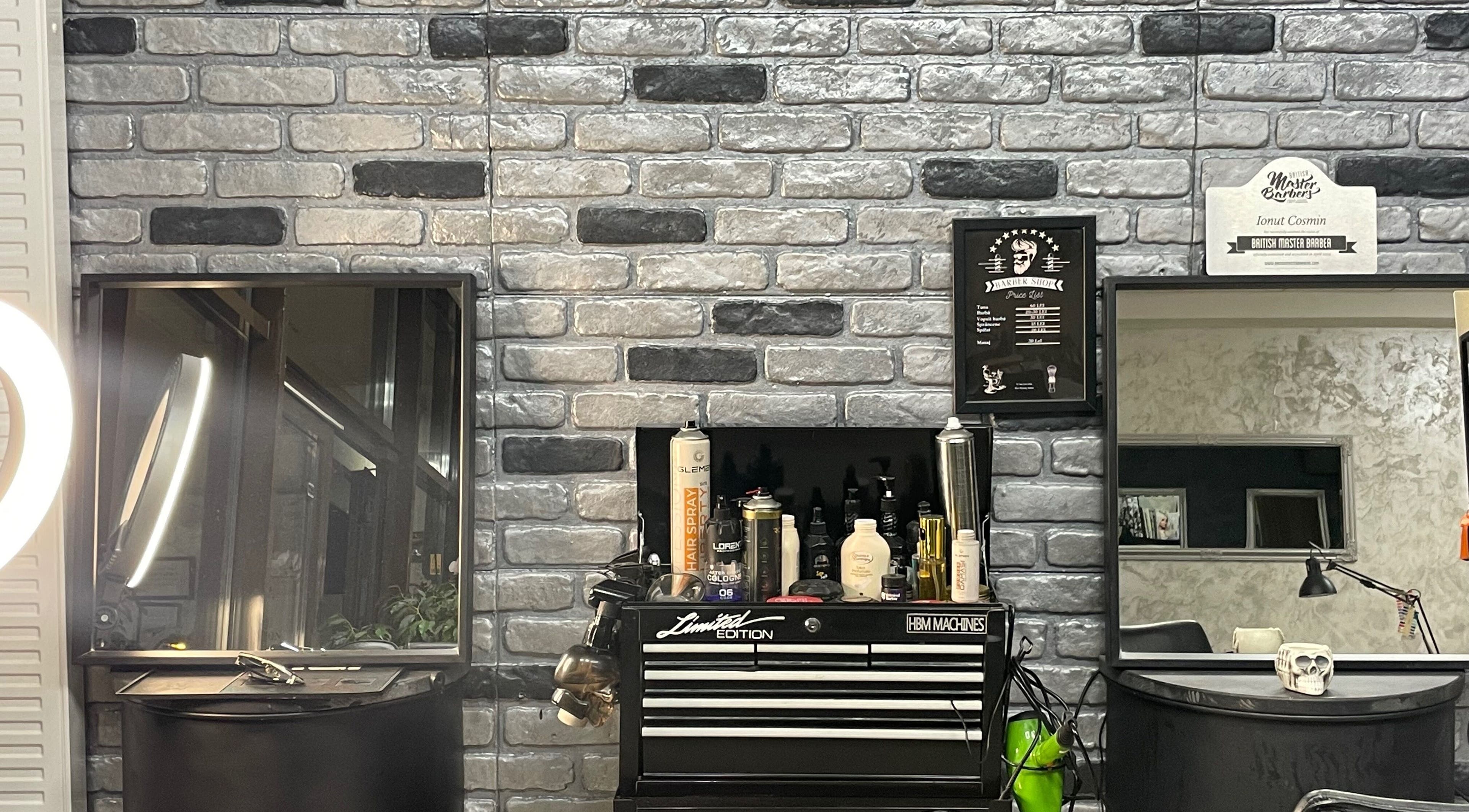 Interior modern Barber din București, București, RO, cu produse de îngrijire pe perete cărămiziu.