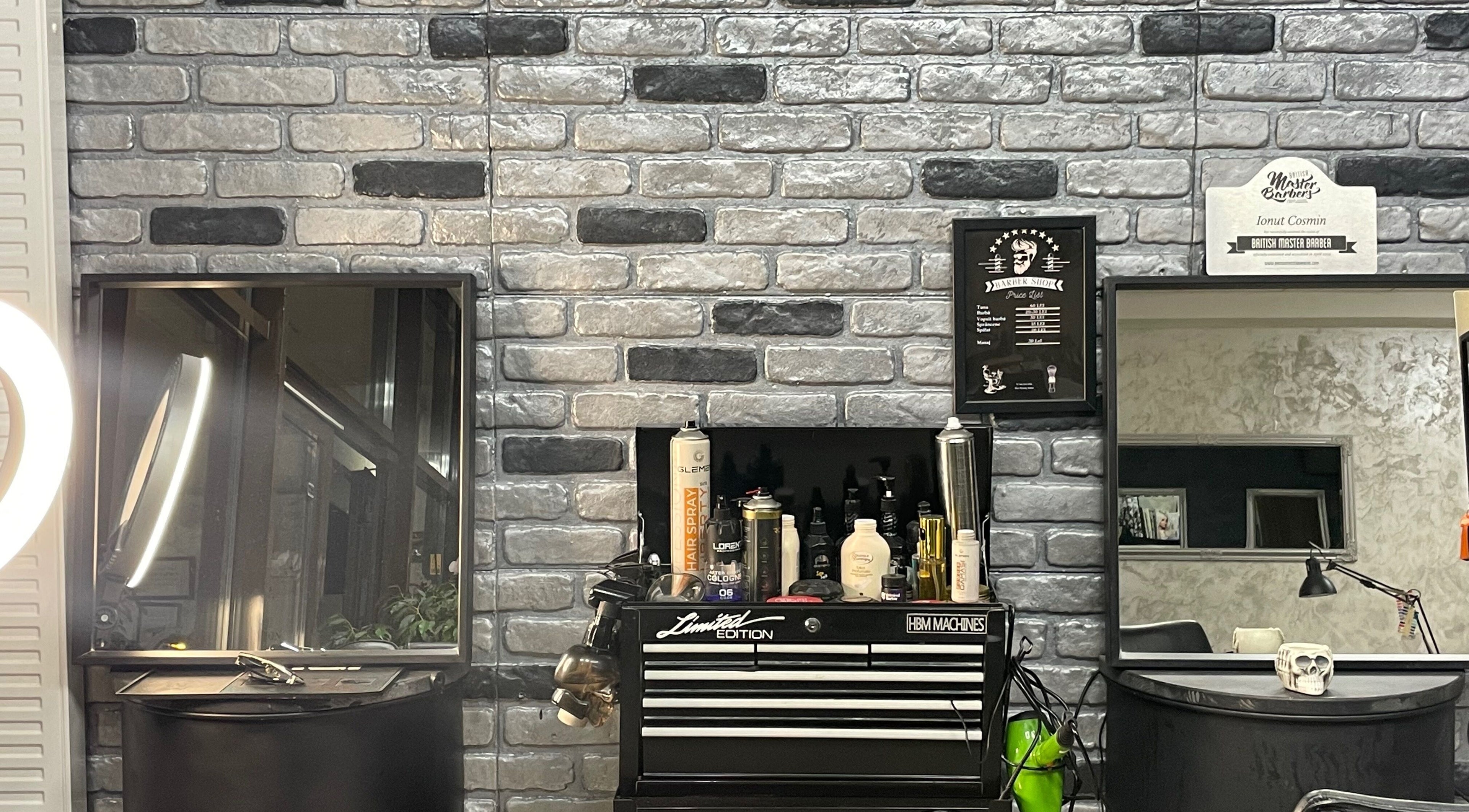 Interior modern Barber din București, București, RO, cu produse de îngrijire pe perete cărămiziu.