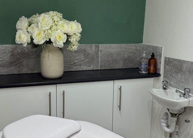 Elegant treatment room at House of Refine in Nottingham, England, GB featuring white roses and chic decor.