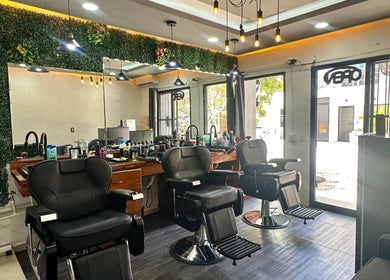 Interior moderno del salón en DON MORETTI, Tulum, Quintana Roo, MX, con sillas de peluquería elegantes.