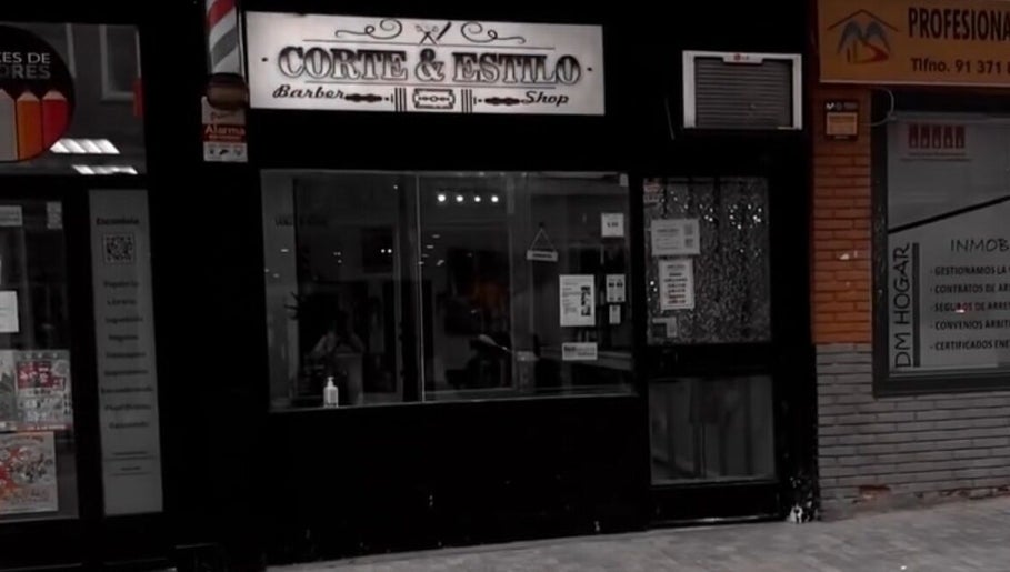 Fachada de Corte & Estilo, barbería en Madrid, Comunidad De Madrid, ES, destacando su entrada iluminada.