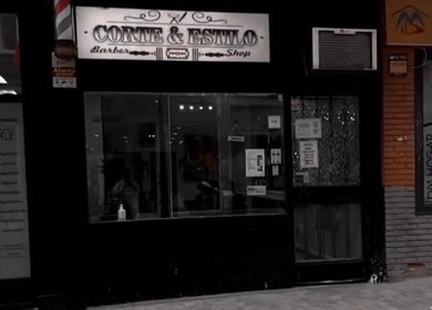 Fachada de Corte & Estilo, barbería en Madrid, Comunidad De Madrid, ES, destacando su entrada iluminada.