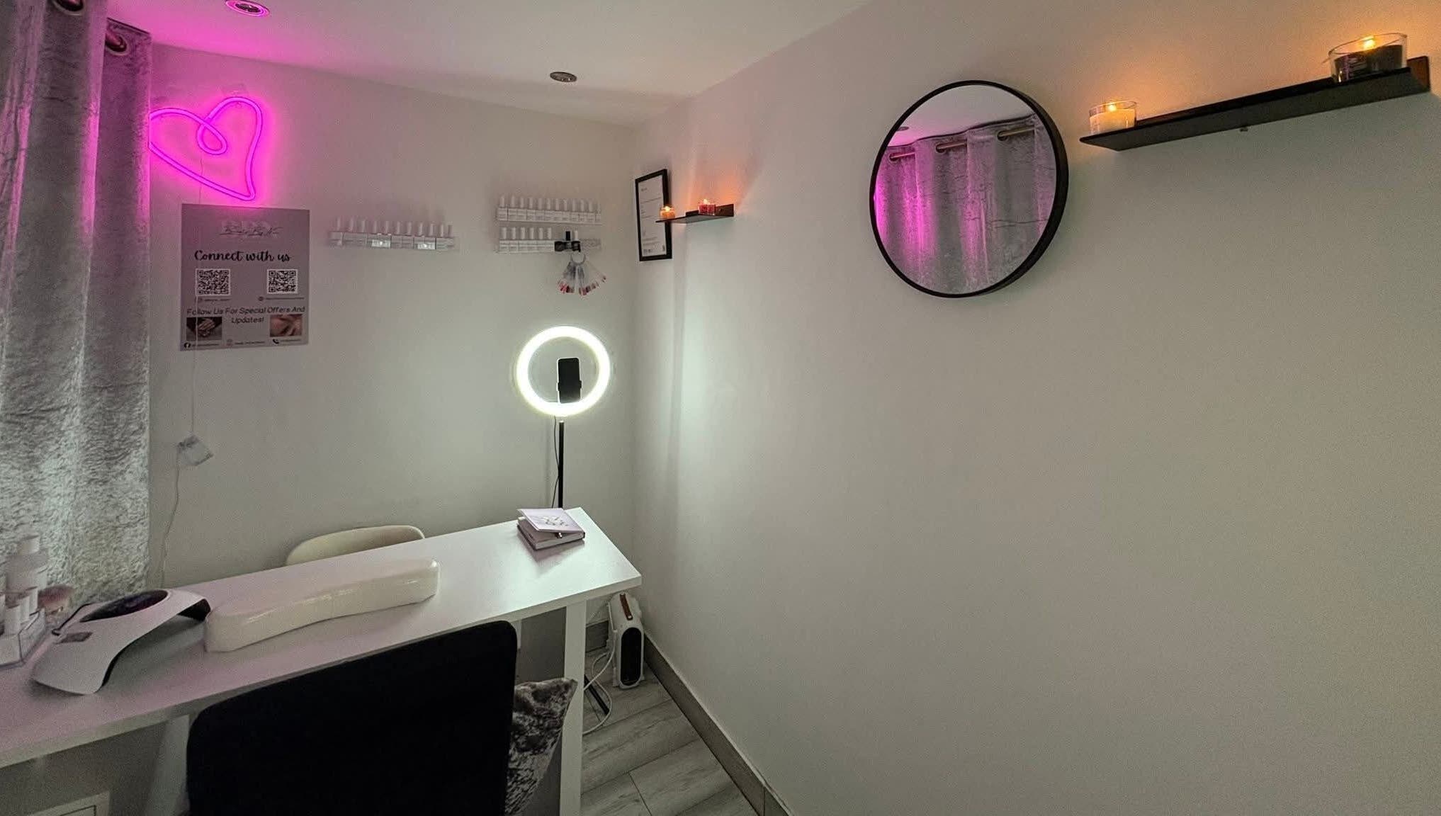 Cozy nail salon interior at Nails by Lu, Lusaka, with neon heart and candles creating a relaxing ambiance.