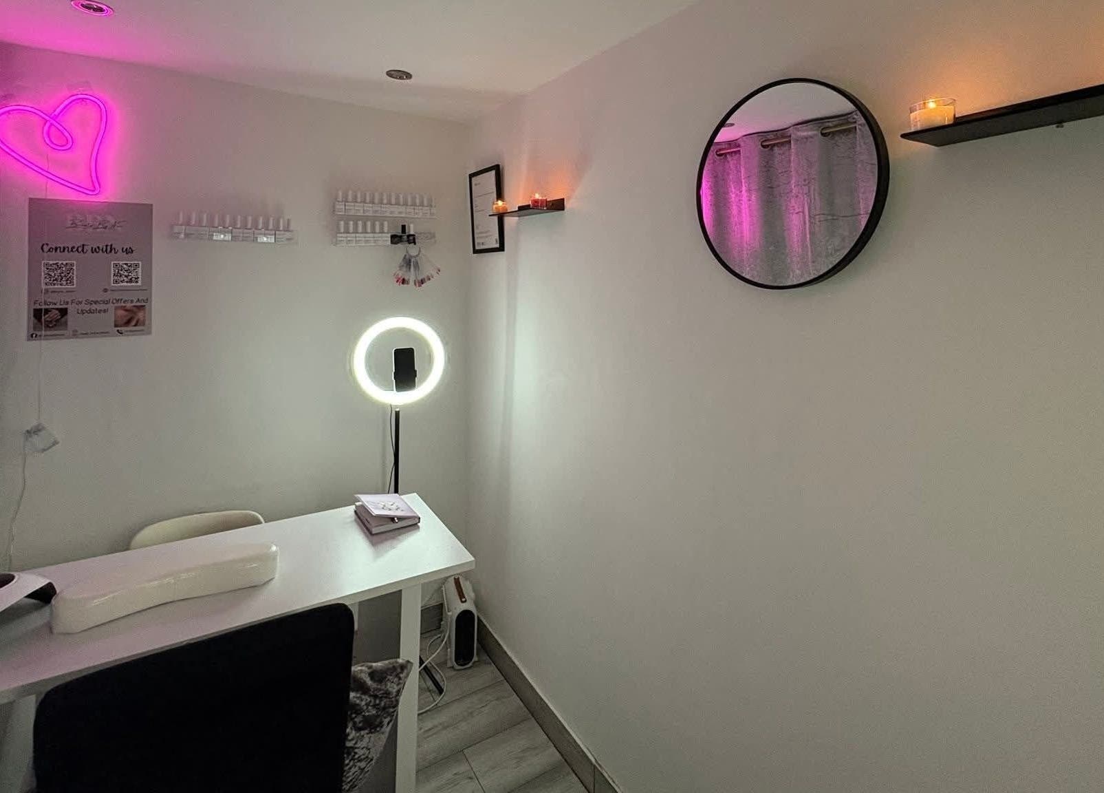 Cozy nail salon interior at Nails by Lu, Lusaka, with neon heart and candles creating a relaxing ambiance.