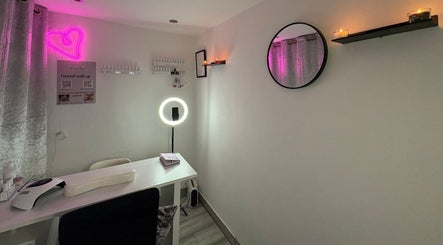 Cozy nail salon interior at Nails by Lu, Lusaka, with neon heart and candles creating a relaxing ambiance.