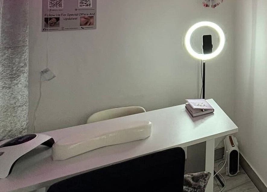 Nail station at Nails by Lu in Lusaka, Lusaka Province, ZM, with a modern lamp and cozy seating.