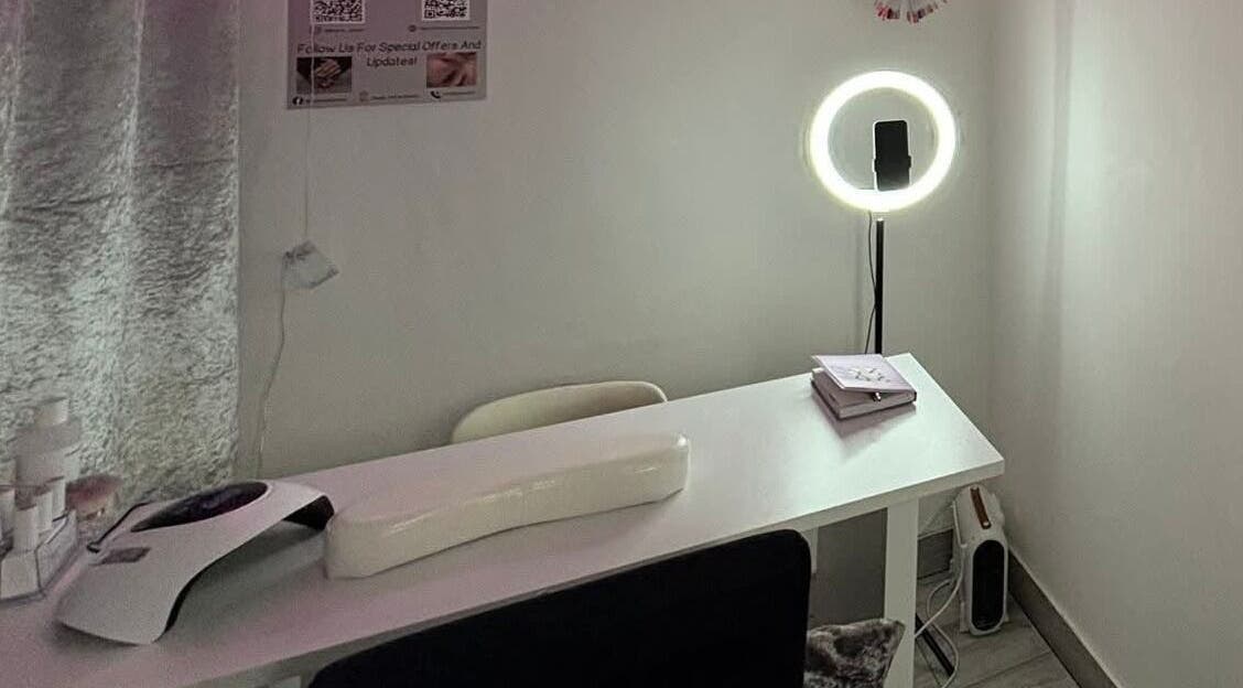 Nail station at Nails by Lu in Lusaka, Lusaka Province, ZM, with a modern lamp and cozy seating.