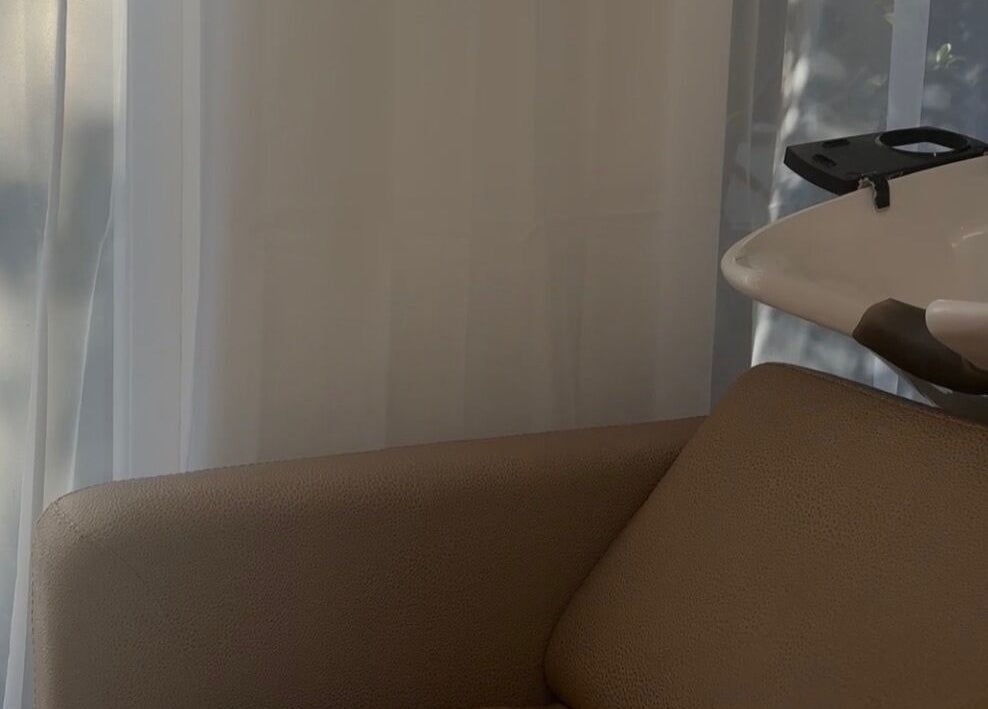 Elegant shampoo station at Locks Of Luxury, Portsmouth, England, GB, with cushioned seating and serene curtains.