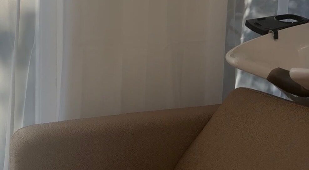 Elegant shampoo station at Locks Of Luxury, Portsmouth, England, GB, with cushioned seating and serene curtains.