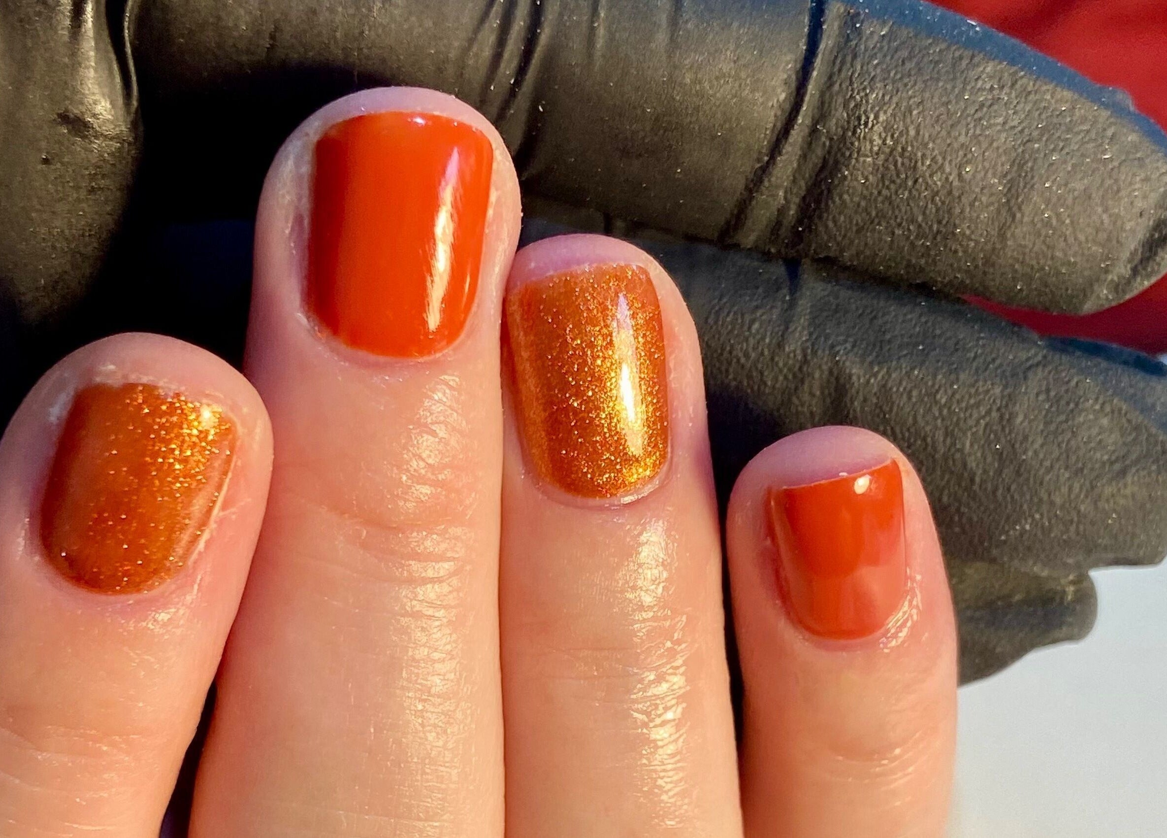 Orange glitter manicure at Nails By Ava, Bridgwater, England, GB, highlighting vibrant nail art.