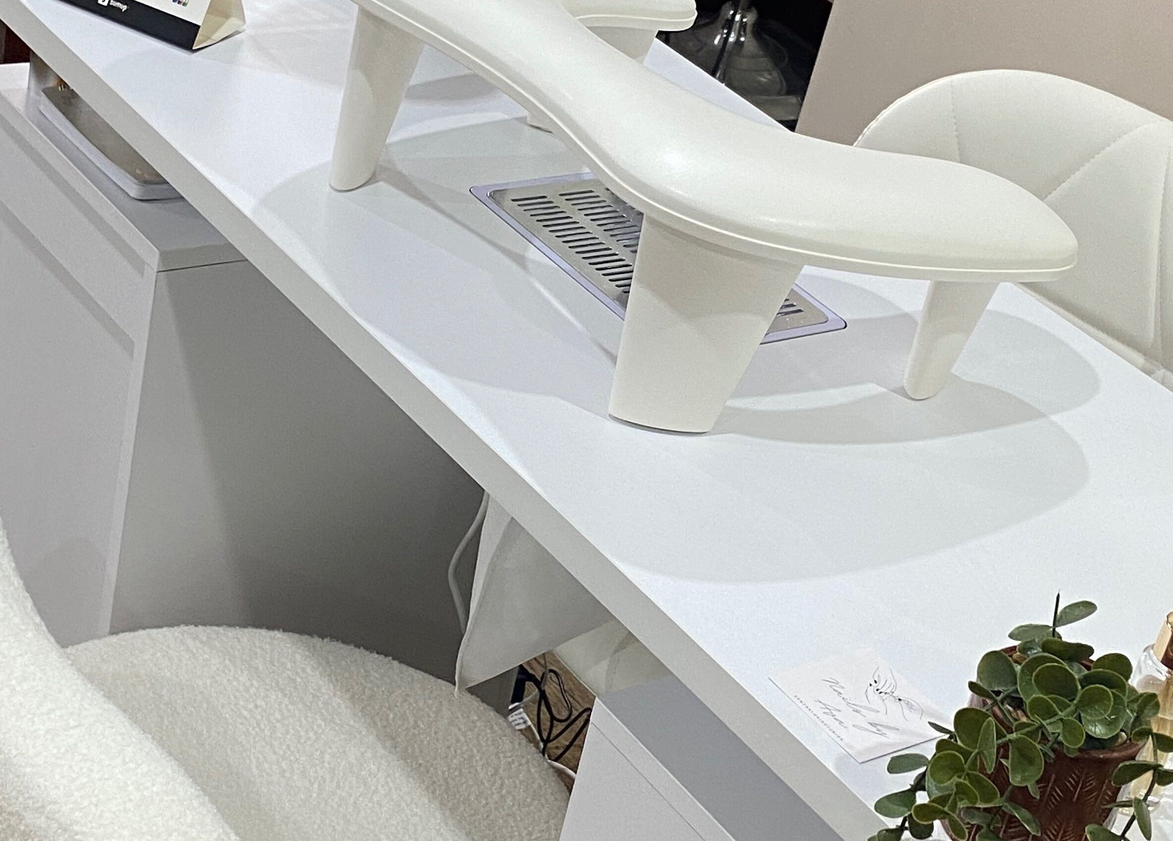 Modern nail station at Nails By Ava in Bridgwater, England, GB with white chairs and greenery.