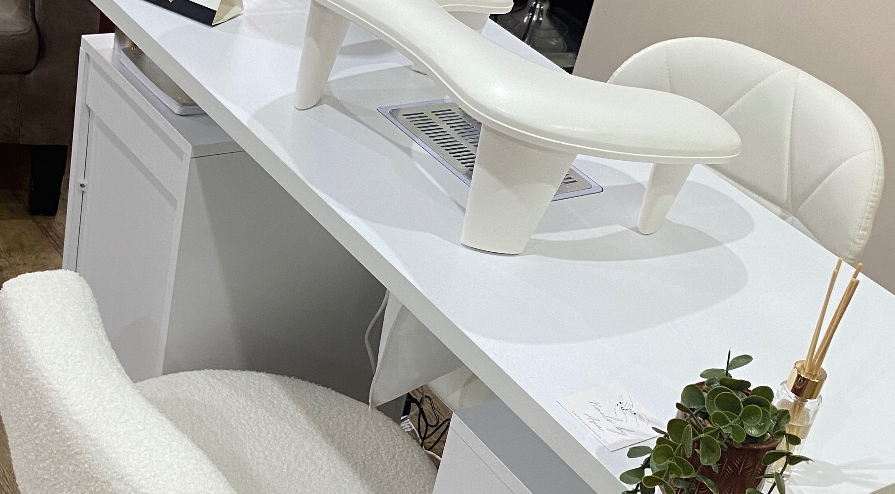 Modern nail station at Nails By Ava in Bridgwater, England, GB with white chairs and greenery.