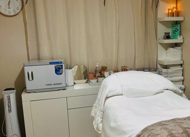 Cozy spa treatment room at Beautique Smiles in Dunlop, Australian Capital Territory, AU with towels and warm lighting.
