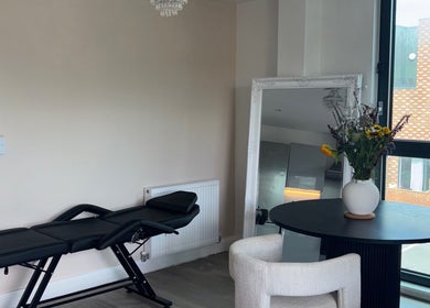 Elegant interior of Lashing by chlo in Ebbsfleet Valley, England, GB with lounge chair and floral decor.