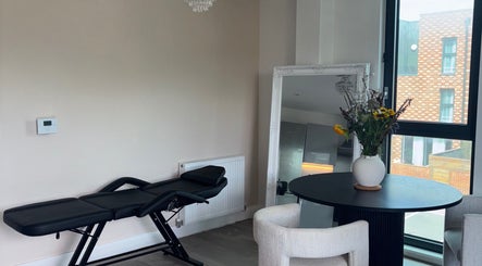 Elegant interior of Lashing by chlo in Ebbsfleet Valley, England, GB with lounge chair and floral decor.