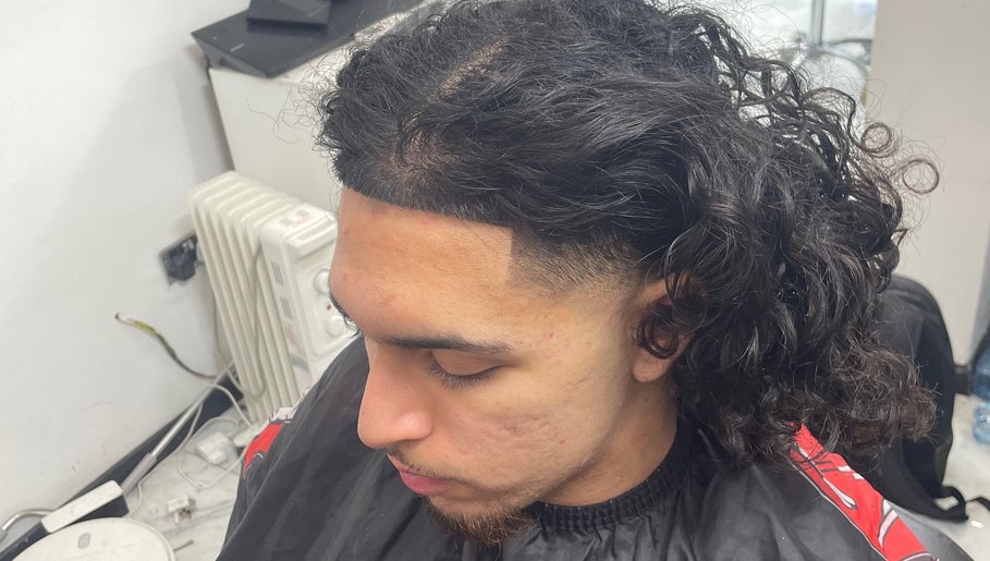 Chic curly hairstyle at trimgudbyhadi in Luton, England, GB offering tailored grooming services.