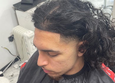 Chic curly hairstyle at trimgudbyhadi in Luton, England, GB offering tailored grooming services.