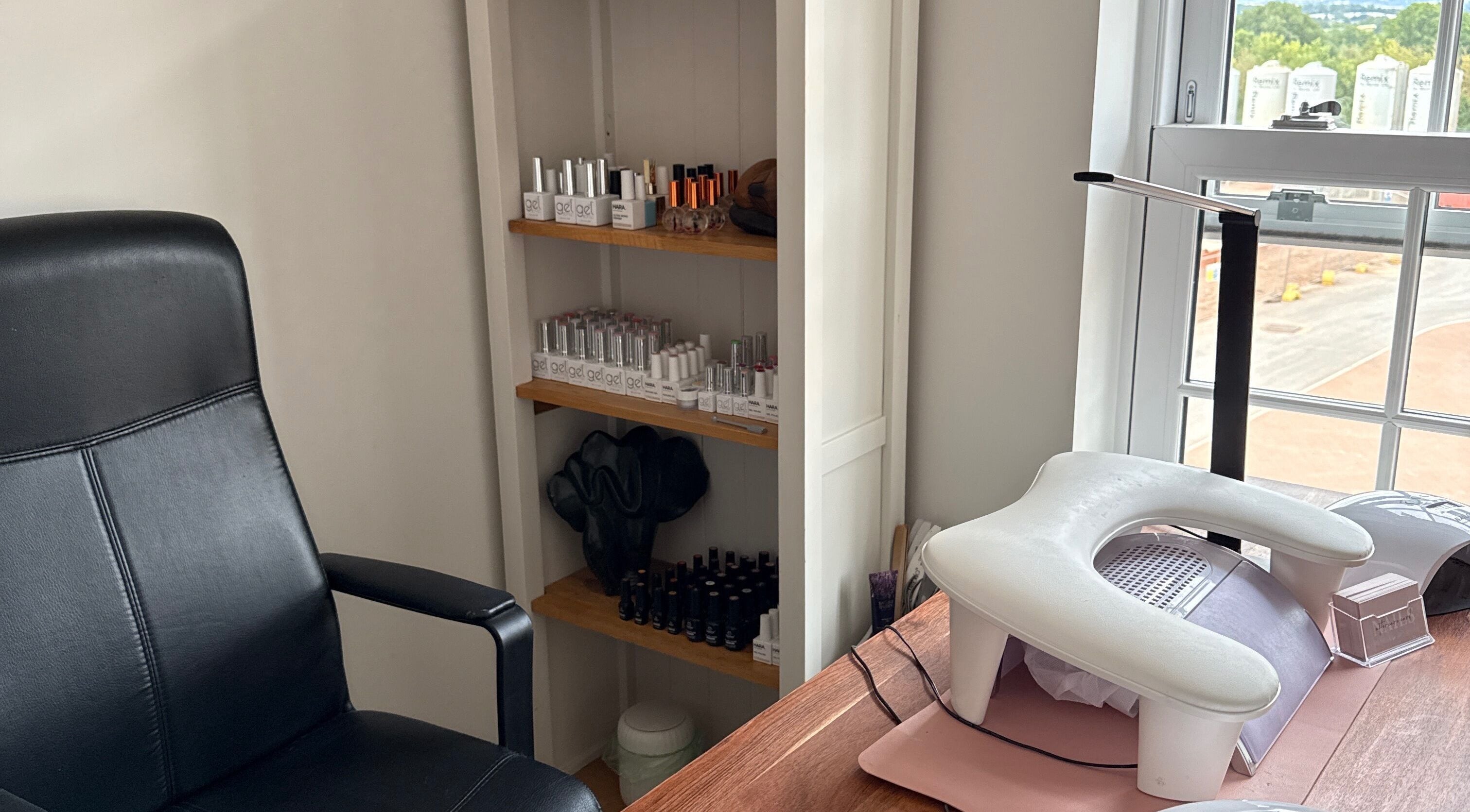Nail care setup at Emily at No.9, Wellington, England, GB, featuring a black chair and shelves with nail products.